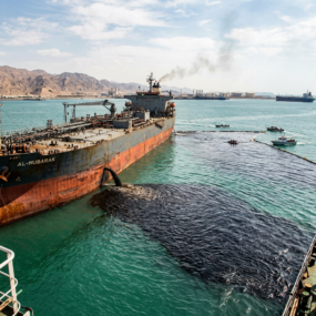 Oil spill spreading from Al-Mubarak tanker with boats deploying containment boom