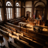 Empty courtroom with wooden benches, judge's bench, and American flags